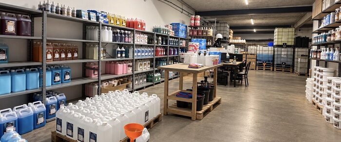 Rayonnages de l’entrepôt d’Argonay chargés de bidons de lessive, d’assouplissant et de liquide vaisselle